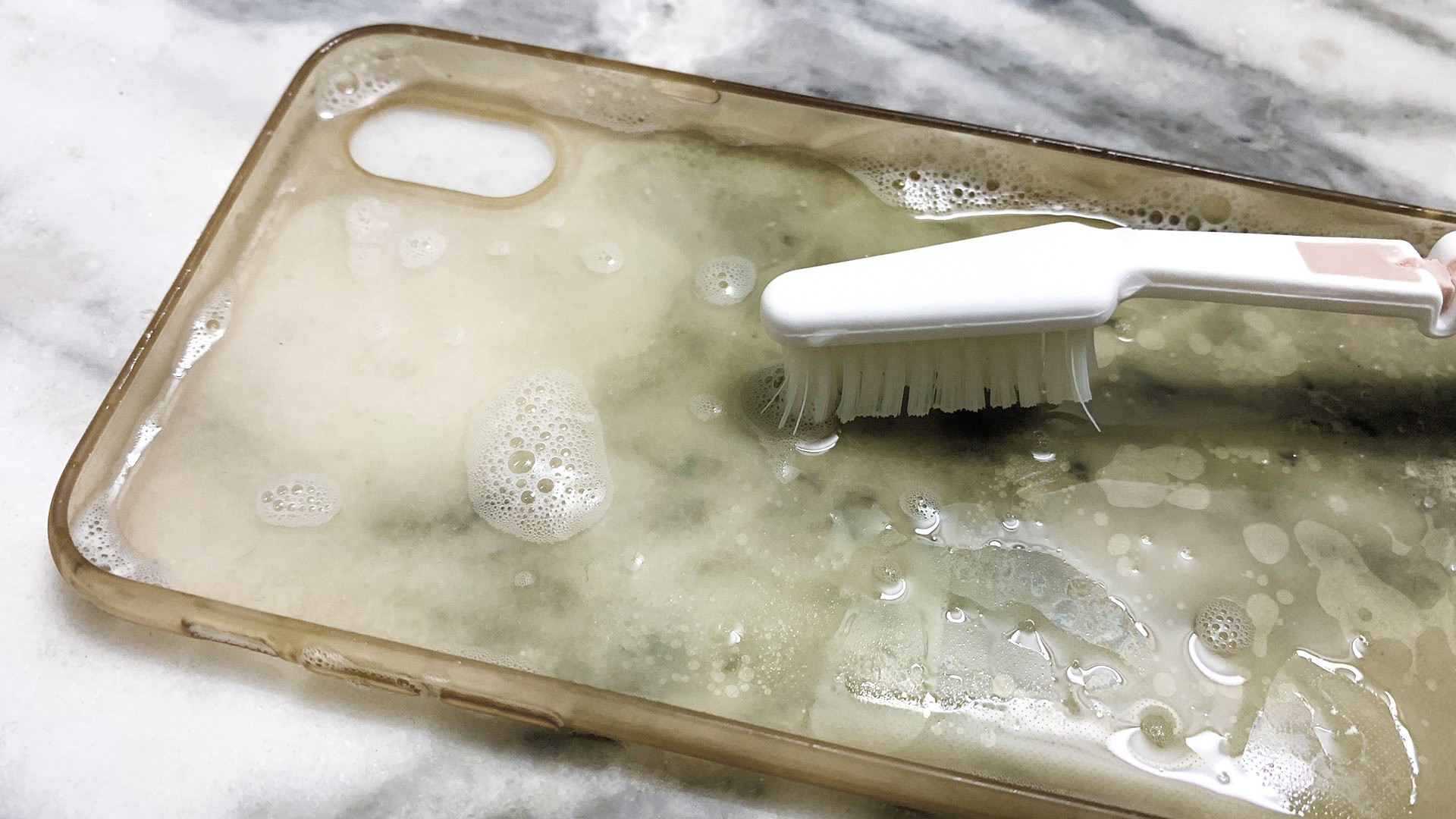 Showing Clean silicon case of iPhone with water and dish soap